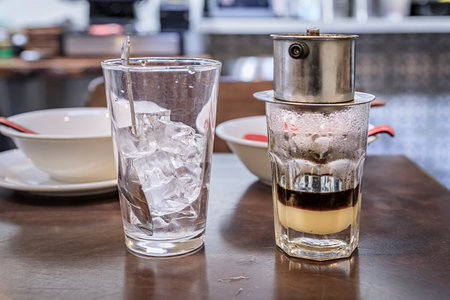 Traditional Vietnamese dark roast drip coffee with condensed milk, Ca Phe Sua Da at a coffee shop...