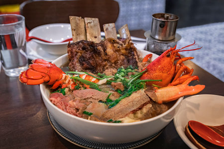 Gourmet exotic version of the Vietnamese pho soup with lobster, short ribs and filet mignon in a...