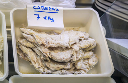 Dried pieces of salted cod or bacalao, traditional Spanish delicacy for sale at a local market in the old town or Casco Viejo in Pamplona, Spain. The tag says heads, 7 euro a kiloの写真素材