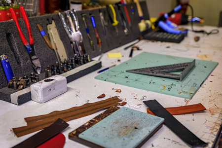 Leather working tools on a work table in the back of a traditional artisanal leather workshop and studio in Centro Storico in Florence, Italyの写真素材