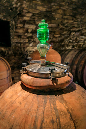 Chianti wine from Sangiovese grapes aging in terracotta clay amphora at a vineyard cellar in the...