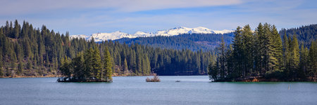 Jenkinson Lake in Sly Park and snow capped Sierra Nevada Mountains in the background in the Northern California in the winterの写真素材