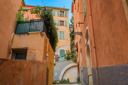 Traditional old houses on a narrow crooked street in the Old Town, Vieille Ville in Nice, French Riviera, South of Franceの写真素材