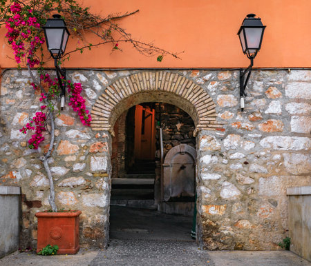 Stone arch in a traditional old terracotta wall between houses in the Old Town of Villefranche sur Mer on the French Riviera, South of Franceの写真素材