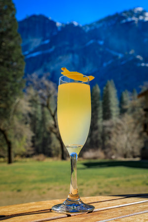 A champagne cocktail on an outdoor table with a view of the famous Yosemite Valley in the background, Yosemite National Park in California, USAの写真素材