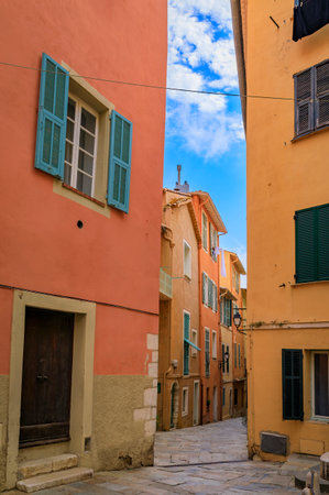 Traditional old terracotta houses on a narrow street in the Old Town of Villefranche sur Mer on the French Riviera, South of Franceの写真素材