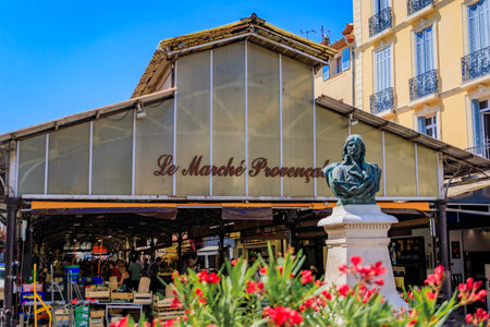 Antibes, France - May 24, 2023: Covered provencal market hall on Cours Massena in the old town Vieil Antibes, framed by blooming flowersのeditorial素材
