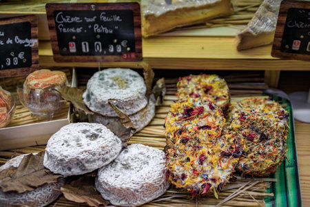 Mature Poitou goat cheese and goat cheese rounds coated with dried flowers at an artisanal cheese shop in the old town Vieil Antibes, South of Franceの写真素材