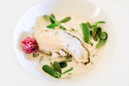 Oyster cooked in a cream sauce at a restaurant on a plate at a restaurant in old town Villefranche sur Mer, South of Franceの写真素材