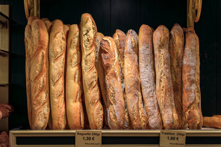 Loaves of freshly baked rustic French baguettes on display at an artisanal bakery in the old town or Vieil Antibes, South of Franceの写真素材