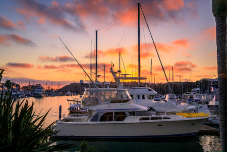 Sunset over luxury yachts and boats in Dana Point harbor, Orange county in Southern Californiaの写真素材