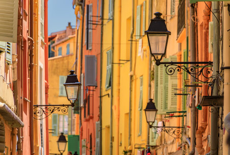 Picturesque old street light, colorful traditional houses with shutters in the background in the old town of Menton, French Riviera, South of Franceの写真素材