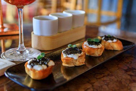 Mini brioche toast with creme fraiche and black sturgeon caviar with a colorful interior at a luxury restaurant, the Carre d Or, Nice, South of Franceの写真素材