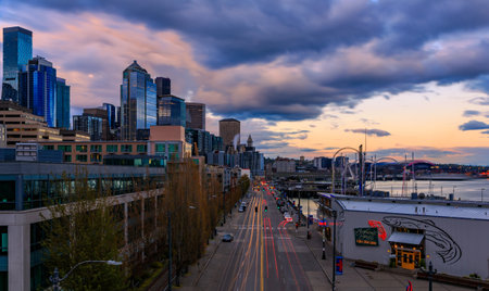 Seattle, Washington - April 27, 2022: Seattle waterfront skyline with a view over the Great Wheel, the Puget Sound and traffic light trails at sunsetのeditorial素材