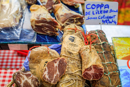 Antibes, France - May 24, 2023: Corsican coppa dry cured pork cold cut for sale on a stand at a local covered provencal farmers market in the old townのeditorial素材