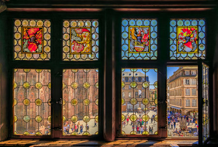 Strasbourg, France - May 31, 2023: Ornate Gothic facade of the Notre Dame Cathedral seen through stained glass window of Maison Kammerzell restaurantのeditorial素材