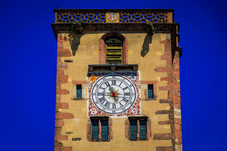 Ornate medieval clock tower with gargoyles in a popular village on the Alsatian Wine Route, in Ribeauville, Franceの写真素材