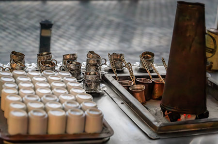 Ornate silver coffee cup holders, ceramic cups and charcoal stove at a traditional Turkish street coffee house cart in Eminonu Istanbul, Turkeyの写真素材