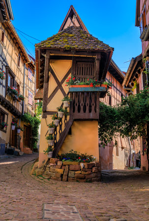 Ornate traditional half timbered houses with blooming flowers in a popular village on the Alsatian Wine Route in Eguisheim, Franceの写真素材