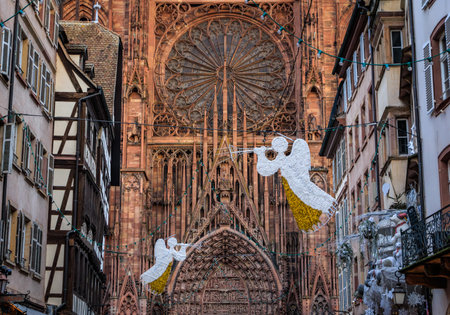 Festive decorations, including angel ornaments, adorn the famous facade of Notre Dame, Strasbourg Cathedral during the Christmas Market in Franceの写真素材