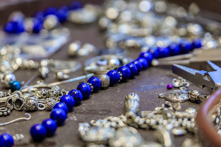 Jeweler s workspace with lapis lazuli and silver beads, tools, for a custom made unique bracelet at the Grand Bazaar in Istanbul, Turkeyの写真素材