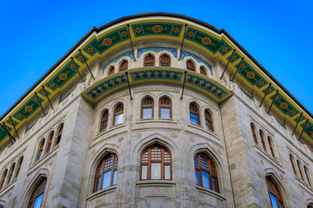 Ornate stone facade with curved lines and arched windows with a vibrant decorative roof overhang with vibrant geometric patterns in Istanbul, Turkeyの写真素材