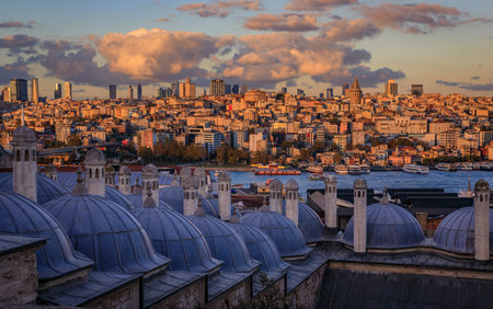 Dramatic sunset over the historic Suleymaniye Mosque domes, with the expansive cityscape and the bustling Golden Horn strait in Istanbul, Turkeyの写真素材