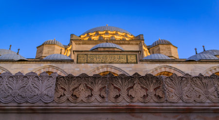 A detailed close up of the Suleymaniye Mosque with ornate stone carvings and the illuminated domes at dusk, sunset blue hour, in Istanbul, Turkeyの写真素材
