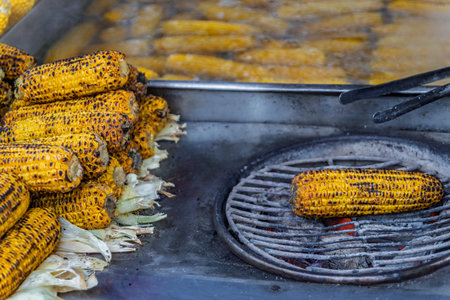 Popular Turkish street food, misir, freshly boiled sweet corn on the cob, roasted on a coal grill...