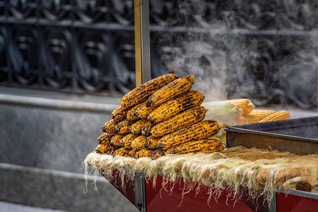 Popular Turkish street food, misir, freshly boiled sweet corn on the cob, roasted on a coal grill and sprinkled with salt and spices, Istanbul, Turkeyの写真素材