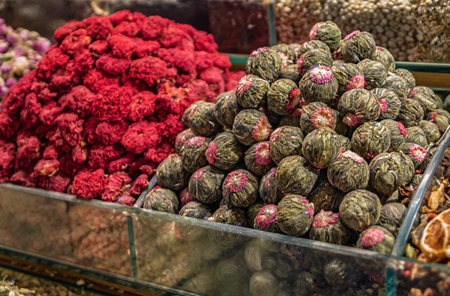 Colorful pomegranate flower or hibiscus tea and blooming tea jasmine flower balls at a traditional market stall at Egyptian Bazaar, Istanbul, Turkeyの写真素材