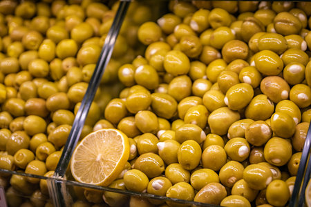A vibrant display of bright green olives stuffed with garlic on display at the bustling Egyptian Bazaar, Istanbul, Turkey, trade and food cultureの写真素材