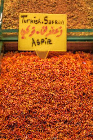 A vibrant display of bright orange safran and other colorful spices at the bustling Egyptian Bazaar market, Istanbul, Turkey, trade and food cultureの写真素材