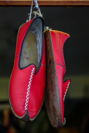 Red handmade pointed toe Turkish leather shoes or Yemeni slippers with traditional stitching on an...