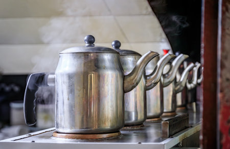 A line of old traditional Turkish teapots on an industrial stove making tea at a teahouse in the...