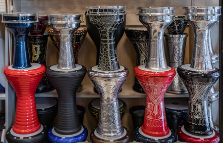 Colorful hand painted darbuka drums displayed on shelves in a music shop, showcasing traditional Turkish percussion instruments in Istanbul, Turkeyの写真素材