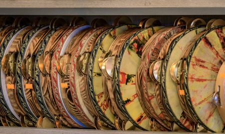 Colorful traditional tambourines with metal jingles and intricate patterns arranged in a neat row for display in a music shop in Istanbul, Turkeyの写真素材