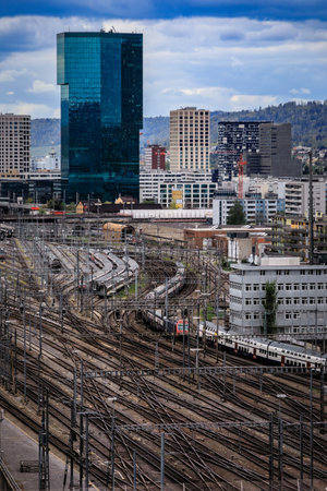 Aerial view of train tracks leading into the main train station, modern skyscrapers and residential buildings in the background in Zurichの写真素材