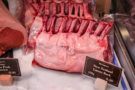 Vacuum sealed racks of New Zealand lamb with expensive price tags displayed at a butcher shop in...