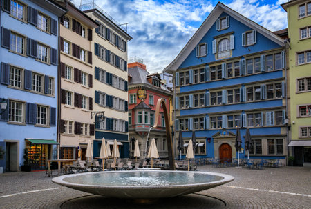 The famous Munsterhof square with colorful historic landmark buildings and a fountain in the Altstadt or Old Town of Zurich, Switzerlandの写真素材