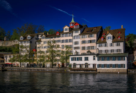 Cityscape with historic buildings on the banks of the Limmat River flowing through Altstadt city center, the waterfront in Zurich, Switzerlandの写真素材