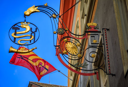 Ornate historic gilded wrought iron medieval guild sign for the smiths guild featuring a snake, a hammer and a horn, Old Town of Zurich, Switzerlandの写真素材