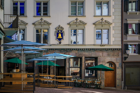Picturesque historic old town square lined with classic buildings and tables at an outdoor...