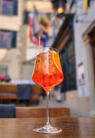 An effervescent spritz cocktail with an orange slice on a table at a charming Swiss outdoor cafe in the Old Town or Altstadt, Zurich, Switzerlandの写真素材