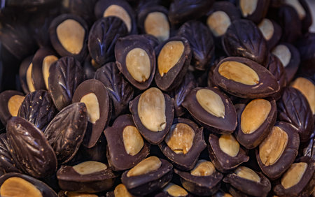 Delicious Turkish nut sweets, chocolate medallions with almonds arranged for sale at a stall at the Egyptian Bazaar, Istanbul, Turkeyの写真素材