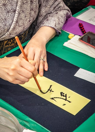 An artist s hand guides a calligraphy brush, creating traditional Japanese script saying buryoku, meaning: power, San Francisco Japantownの写真素材