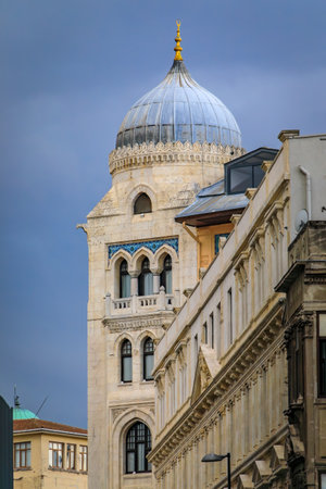 The ornate facade of a historic building with an Ottoman style dome, intricate arches and mosaic tile work against a cloudy sky, Istanbul, Turkeyの写真素材