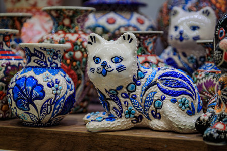 Ornate handmade Turkish ceramic Iznik pottery, a cat figurine and a bowl with a floral pattern in Ottoman style at a souvenir shop in Istanbul, Turkeyの写真素材