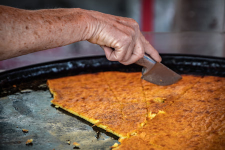 Socca, traditional thin chickpea flour pancake or crepe cooked for sale at farmers market in Cours Saleya in Vieille Ville or Old Town in Nice, Franceの写真素材