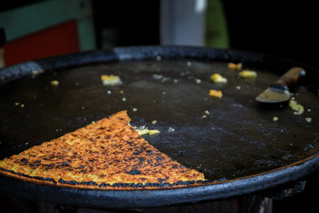 Socca, traditional thin chickpea flour pancake or crepe cooked for sale at farmers market in Cours Saleya in Vieille Ville or Old Town in Nice, Franceの写真素材